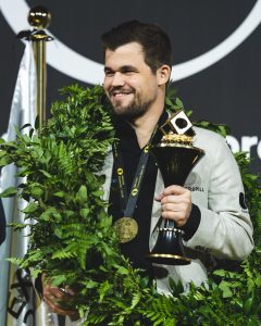 Carlsen med laurbærkrans og VM-trofe